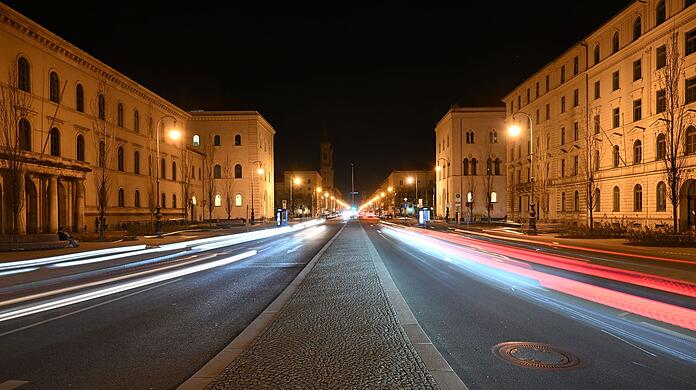 Lichtstreifen von Autoscheinwerfern sind auf der beleuchteten Ludwigsstraße in München zu sehen. (Archivbild)