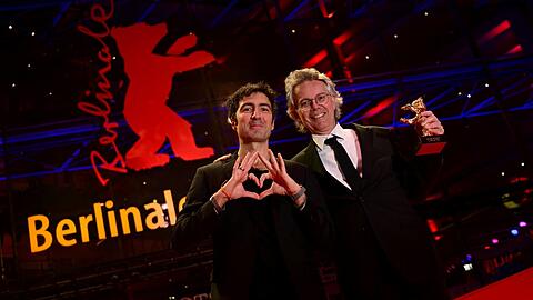 Ilker &Ccedil;atak (li.), Regisseur des Films "Gelbe Briefe", und Produzent Ingo Fliess zeigen den Goldenen B&auml;ren f&uuml;r den &bdquo;Besten Film&ldquo; im Berlinale Palast.