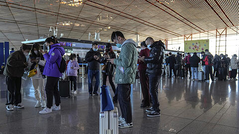 Reisende stehen am Flughafen Peking. Die Corona-Zahlen in China sind hoch - doch Mediziner Christoph Spinner sieht die Lage gelassen.