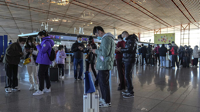 Reisende stehen am Flughafen Peking. Die Corona-Zahlen in China sind hoch - doch Mediziner Christoph Spinner sieht die Lage gelassen.