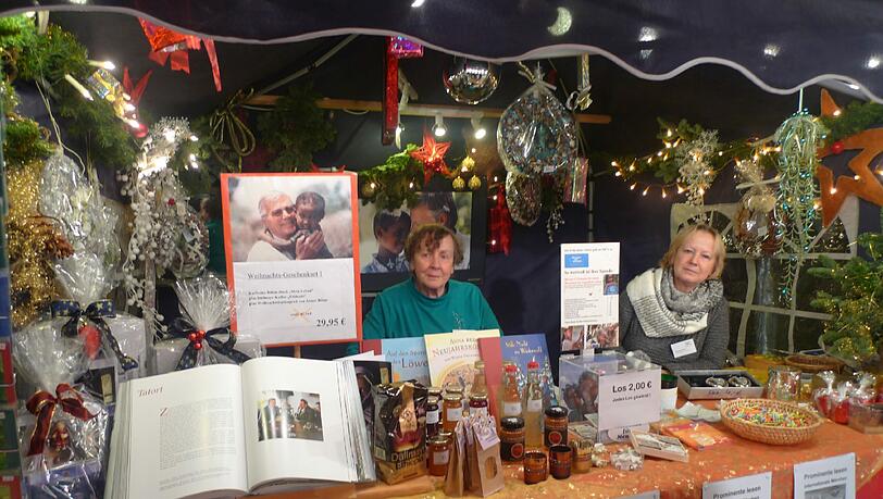 Im Bazar-Zelt auf dem Tollwood-Gelände: die ehrenamtlichen Helferinnen und Helfer des Arbeitskreises Menschen für Menschen. Im Bazar-Zelt auf dem Tollwood-Gelände: die ehrenamtlichen Helferinnen und Helfer des Arbeitskreises Menschen für Menschen.