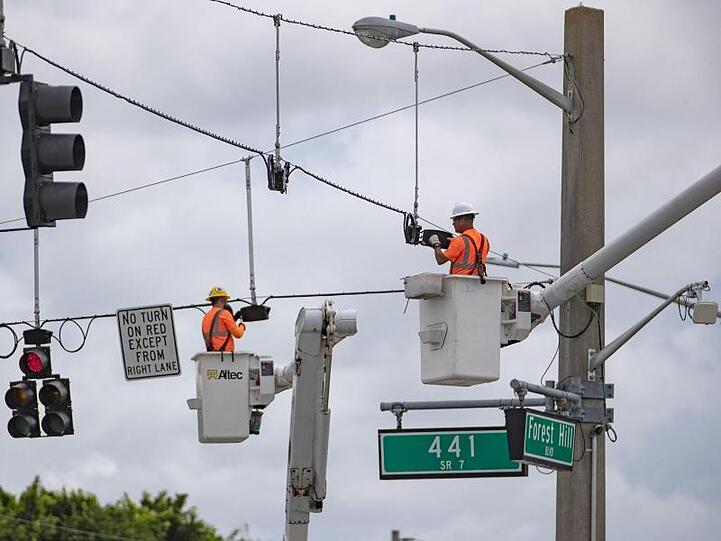 Mitarbeiter des Palm Beach County im Süden des US-Bundesstaats Florida installieren Ampeln, die vor der Ankunft des Hurrikans vorsorglich demontiert worden waren.