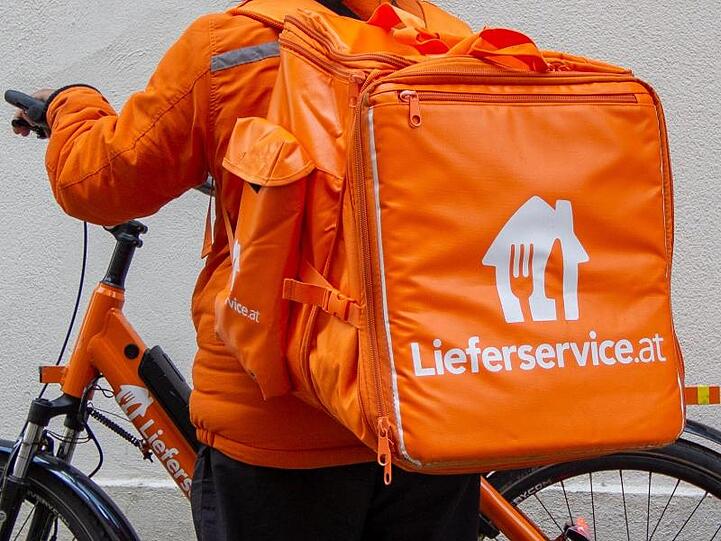 Ein Mitarbeiter von Lieferservice.at steht neben seinem E-Bike. Österreich hat den weltweit ersten Kollektivvertrag für Fahrradzusteller.