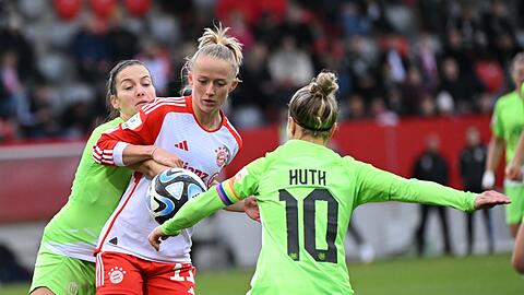 Bayerns Lea Schüller (M) kämpft mit Wolfsburgs Jule Brand (l) und Svenja Huth um den Ball.