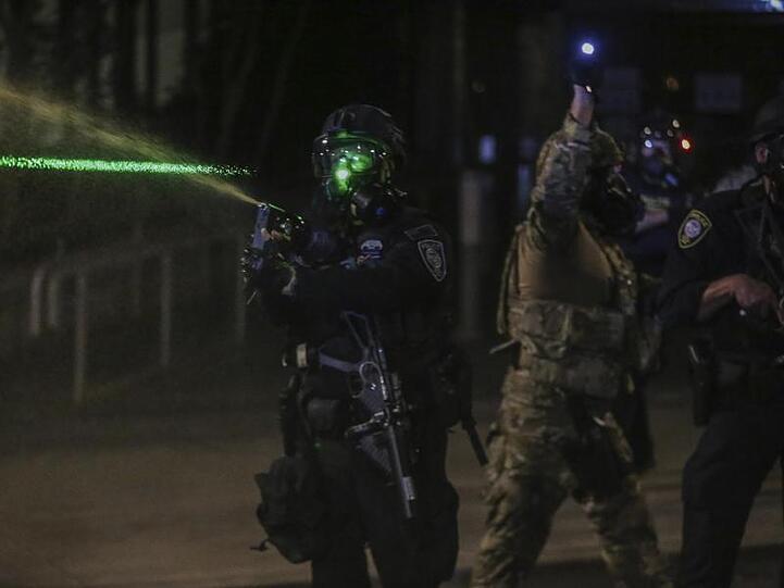 Polizisten gehen mit Tränengas gegen Demonstranten vor.
