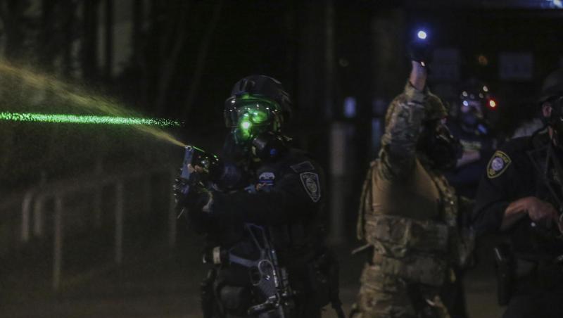 Polizisten gehen mit Tränengas gegen Demonstranten vor. Polizisten gehen mit Tränengas gegen Demonstranten vor.