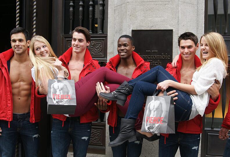 Model Billy (22, links) aus London und sein Kollege Nick (21) aus Pittsburgh/USA tragen die Kundinnen auf Händen bei der Eröffnung des neuen Abercrombie & Fitch-Flagstores in München in der Sendlinger Straße.