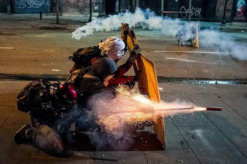 Raketen abgefeuert: Demonstranten der Opposition liefern sich einen Schlagabtausch mit der Polizei in Caracas.