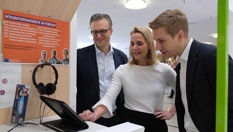 Testen im neuen "Welcome Center" schon mal das IT-Angebot (v.l.): Tobias Schalkhau&szlig;er vom Unternehmen Brainlab, Kreisverwaltungsreferentin Hanna Samm&uuml;ller (Gr&uuml;ne) und B&uuml;rgermeister Dominik Krause (Gr&uuml;ne).