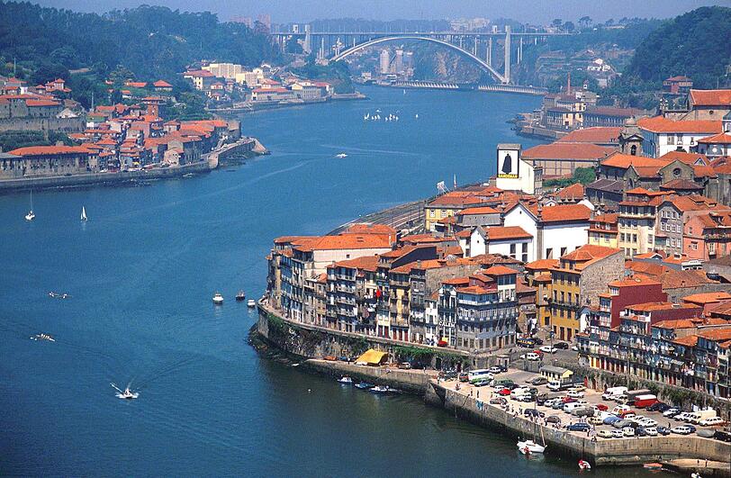Porto: Genuss am Fluss
Herber Charme und süßer Wein: Die Heimatstadt des Portweins hat sich mächtig ins Zeug gelegt. Längst kann sie locker mit dem einst so beneideten Lissabon mithalten. Rund um das Museum für moderne Kunst hat sich eine schillernde Clubszene etabliert. In der Altstadt Ribeira schiebt man sich durch enge Gassen, über kleine Plätze, vorbei an schmalen Häuserfassaden. Hier gibt es jede Menge Bars, Cafés und exzellente Restaurants. Mutige probieren die Spezialität der Stadt "Tripas ao modo do Porto": Kutteln mit weißen Bohnen. Schwindelfrei muss sein, wer den Gang über den "liegenden Eiffelturm" wagt, die 50 Meter hohe Eisengitterbrücke Ponte Luis, die tatsächlich von Gustave Eiffel und einem seiner Schüler stammt. Ein Muss ist dann natürlich die Besichtigung einer der alten Portweinkellereien wie Sandeman oder Osborne, die alle entlang des Flusses Douro ihre Sitze haben. Obst und Gemüse, aber auch schöne Souvenirs ersteht man im Mercado do Bolhao, einer hundert Jahre alten gedeckten Markthalle in einem wunderschönen Art déco-Gebäude.
Nach Porto fliegen Air Berlin und Ryanair von 15 deutschen Flughäfen. Preise ab 20 Euro für die einfache Strecke.