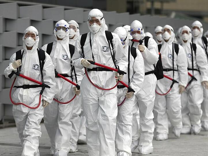 Soldaten der südkoreanischen Armee tragen Schutzkleidung und versprühen Desinfektionsmittel am Bahnhof Dongdaegu.