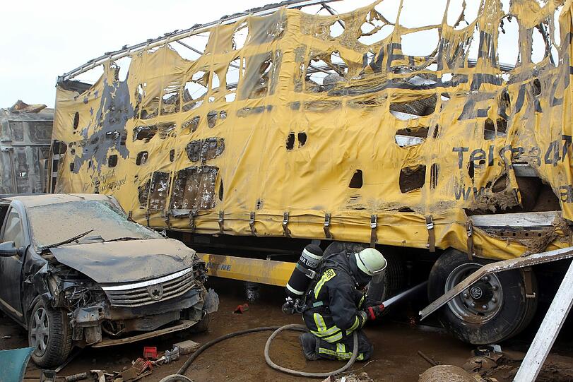 Feuerwehrleute sind am Freitag auf der Autobahn A19 bei Kavelstorf in der Nähe von Rostock bei einer Massenkarambolage im Einsatz. Bei einem Sandsturm fuhren in beiden Fahrtrichtungen Dutzende Fahrzeuge und LKW ineinander und brannten teilweise aus.