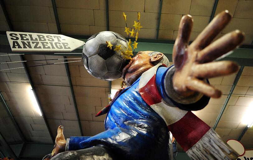Der Maizer Motivwagen "Eigentor" zeigt den Präsidenten des Fußballvereins FC Bayern München, Uli Hoeneß, der einen Ball mit der Aufschrift "Selbstanzeige" ins Gesicht bekommt.