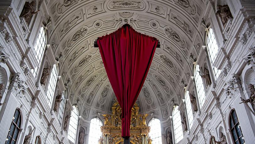 Karwoche: Ein rotes Tuch verhüllt in der Michaelskirche das Kreuz vor dem Altar. Karwoche: Ein rotes Tuch verhüllt in der Michaelskirche das Kreuz vor dem Altar.