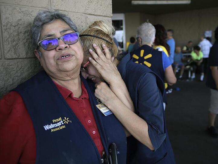 Fassungslos stehen Mitarbeiter von Walmart vor der Tür des Ladenkomplexes in El Paso.