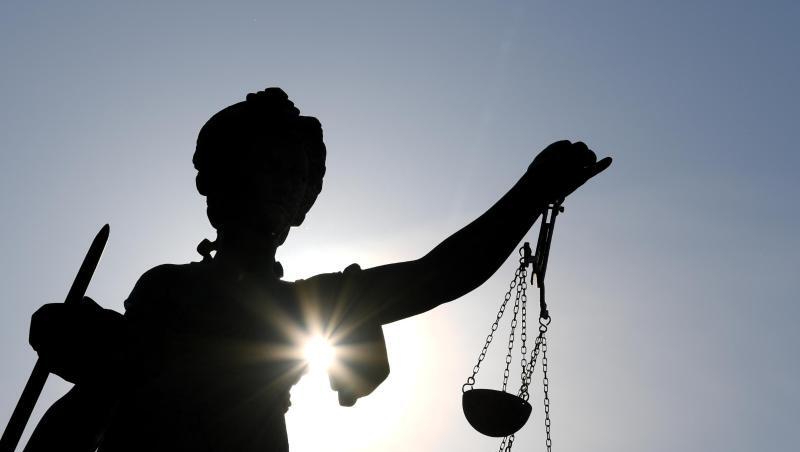 Die Statue der Justitia steht mit einer Waage und einem Schwert in der Hand.