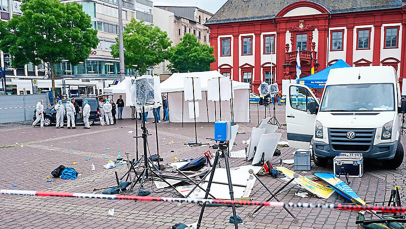 Mitarbeiter der Spurensicherung stehen auf dem Mannheimer Marktplatz hinter einem zertrümmerten Stand eines islamfeindlichen Vereins. Bei einem Einsatz hat die Polizei einen Angreifer niedergeschossen. Verwickelt in die Auseinandersetzung war ein Münchner.