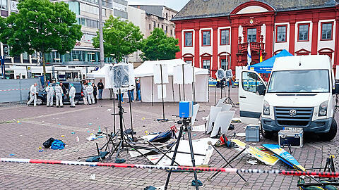 Mitarbeiter der Spurensicherung stehen auf dem Mannheimer Marktplatz hinter einem zertrümmerten Stand eines islamfeindlichen Vereins. Bei einem Einsatz hat die Polizei einen Angreifer niedergeschossen. Verwickelt in die Auseinandersetzung war ein Münchner.