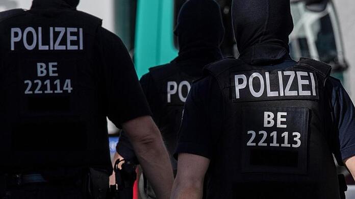Berliner Polizisten gehen über eine Straße.