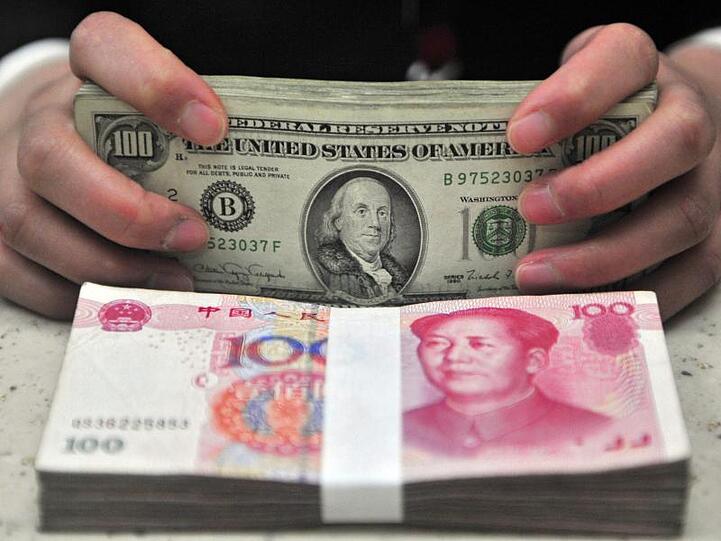 Geldbündel von US-Dollars und chinesischem Renminbi. Das Interesse ausländischer Investoren an deutschen Unternehmen hält an.