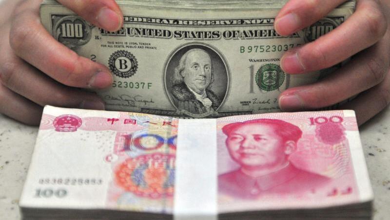 Geldbündel von US-Dollars und chinesischem Renminbi. Das Interesse ausländischer Investoren an deutschen Unternehmen hält an. Geldbündel von US-Dollars und chinesischem Renminbi. Das Interesse ausländischer Investoren an deutschen Unternehmen hält an.