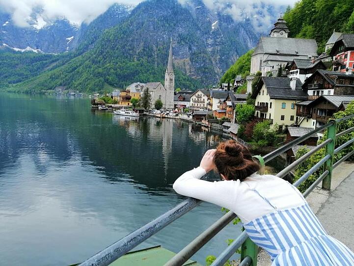 Eine Touristin fotografiert den Hallstätter See in Österreich. Hier scheint die Welt selbst im Corona-Sommer in der üblichen Ordnung zu sein.