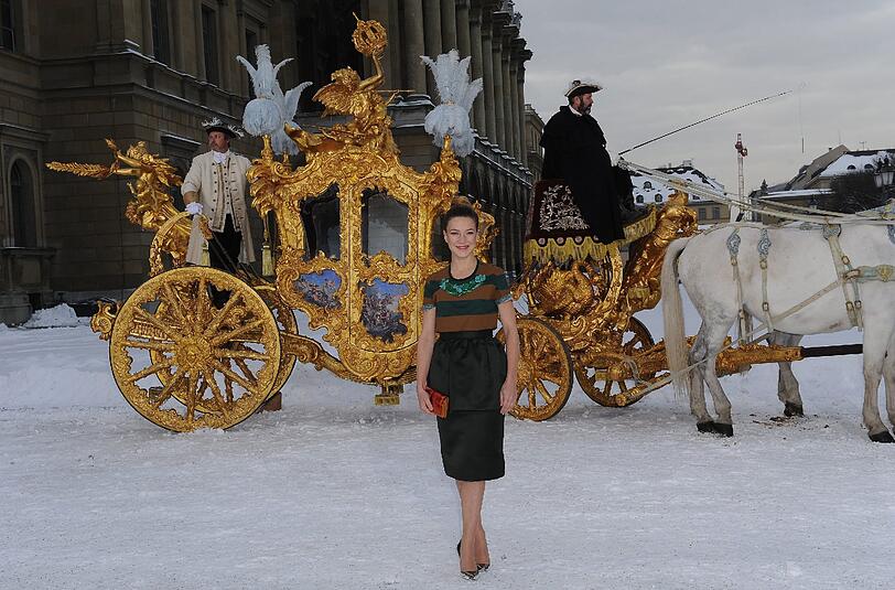 Hannah Herzsprung (Kaiserin Elisabeth von Österreich) posiert im Hofgarten in München vor der goldenen Kutsche aus dem Film.