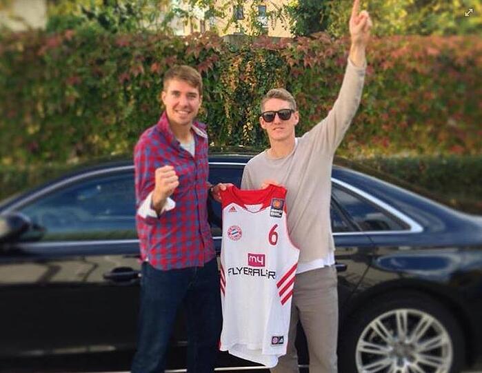 Basketballer Steffen Hamann überreicht Fußballer Bastian Schweinsteiger ein neues Trikot.