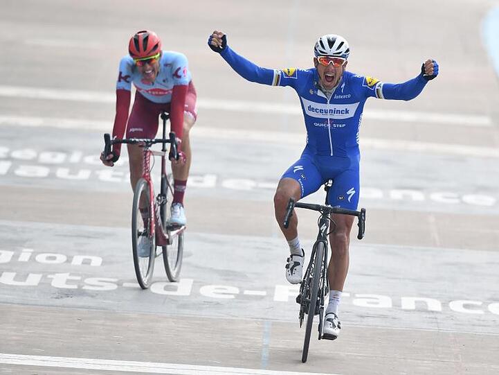 Philippe Gilbert (r) aus Belgien überquert jubelnd als Sieger die Ziellinie, während hinter ihm Nils Politt Zweiter wird.