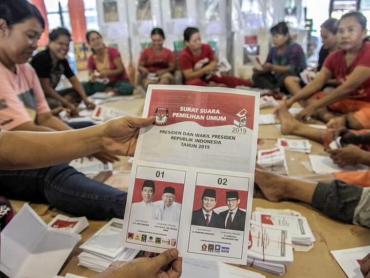 Wahlhelfer falten Stimmzettel, die an Wahlstationen in der Provinz Sumatra Utara verteilt werden.