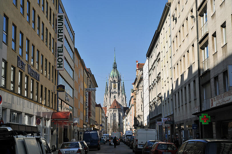 Durch die Landwehrstraße drängeln sich die Autofahrer vorbei an kleinen Hotels und Geschäften. Wer weiter blickt, schaut Richtung Paulskirche.