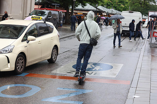 Auch E-Scooter dürften in der Fußgängerzone auf dem Münchner Viktualienmarkt eigentlich nicht fahren.
