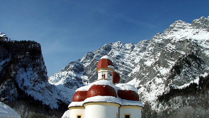 Beliebtes Ausflugsziel am Westufer des Königssees ist die Wallfahrtskirche St. Bartholomä. Ist der Königssee zugefroren, spazieren Menschen über das Eis zur Kirche. Beliebtes Ausflugsziel am Westufer des Königssees ist die Wallfahrtskirche St. Bartholomä. Ist der Königssee zugefroren, spazieren Menschen über das Eis zur Kirche.