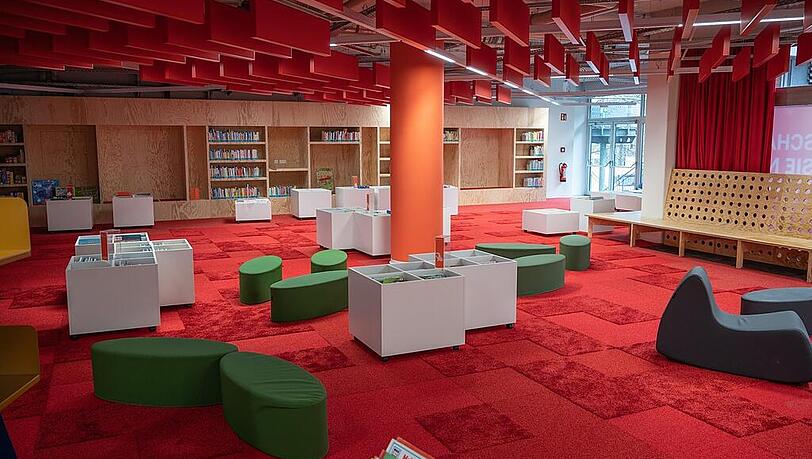 Ganz in Rot: Der sehr belibte Bereich Kinder/Familie im Motorama: Die jungen Leser k&ouml;nnen in den niedrigen B&uuml;cherboxen st&ouml;bern, die ganz jungen k&ouml;nnen &uuml;ber den strukturierten Teppich krabbeln.