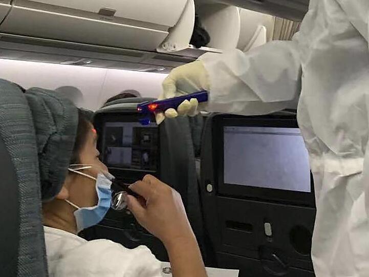 Nach der Landung auf dem Flughafen in Rom, wird in einem Flugzeug aus Hongkong die Temperatur der Passagiere gemessen.