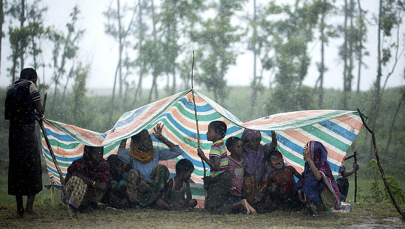 Rohingya-Flüchtlinge aus Myanmar sitzen in der Stadt Cox’s Bazar in Bangladesch unter einer Plastikplane, um sich vor Regen zu schützen. Seit Ende August sind laut UN-Schätzungen gut 400.000 Rohingyas aus Myanmar geflohen. Rohingya-Flüchtlinge aus Myanmar sitzen in der Stadt Cox’s Bazar in Bangladesch unter einer Plastikplane, um sich vor Regen zu schützen. Seit Ende August sind laut UN-Schätzungen gut 400.000 Rohingyas aus Myanmar geflohen.