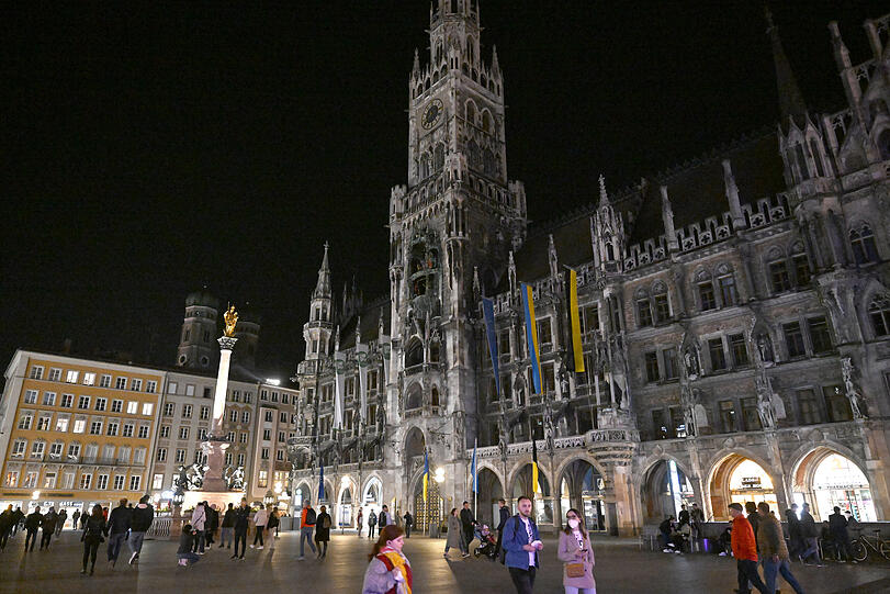 Das Rathaus am Marienplatz während der "Earth Hour 2022": Trotz Corona-Zeit kamen einige Münchner, um sich das Spektakel anzusehen.