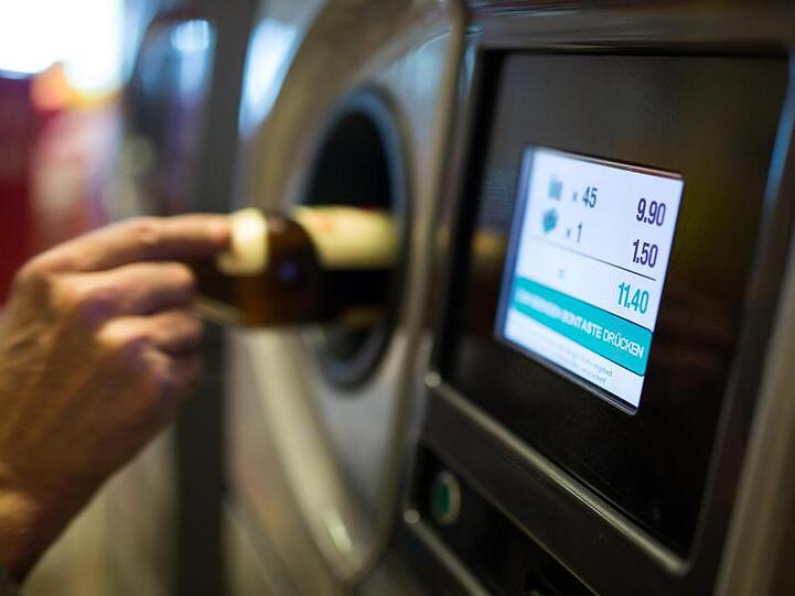 Ein Flaschensammler gibt Pfandflaschen an einem Automaten ab. Weil sie einen Pfandflaschenautomaten manipuliert haben sollen, stehen drei Männer vor Gericht.