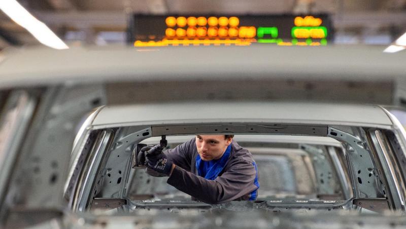 Ein Mitarbeiter schraubt im Karosseriebau im Werk in Wolfsburg an einem Volkswagen. Ein Mitarbeiter schraubt im Karosseriebau im Werk in Wolfsburg an einem Volkswagen.