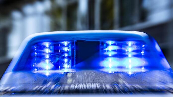 Das Blaulicht an einem Polizeiwagen blinkt.