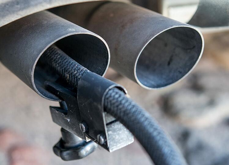 Ein Messschlauch eines Gerätes zur Abgasuntersuchung für Dieselmotoren steckt im Auspuffrohr eines VW Golf 2.0 TDI.