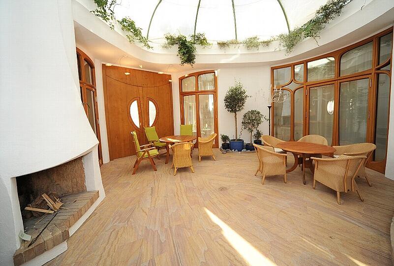 Neben dem Wohnzimmer liegt der Wintergarten - mit einem der insgesamt sieben Kamine.