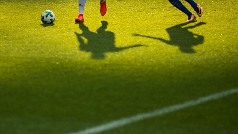 Zwei Fußballspieler kämpfen um den Ball.
