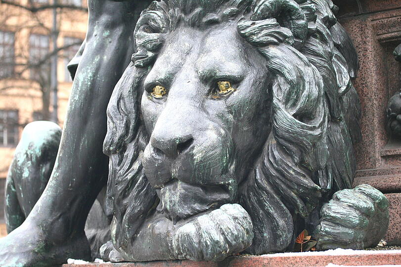 Im November 2010 hatten Unbekannte dem Löwen die Augen angemalt, der Figur daneben die Nägle lackiert. Die Entfernung löste auch die Patina, die bildet sich seitdem neu.