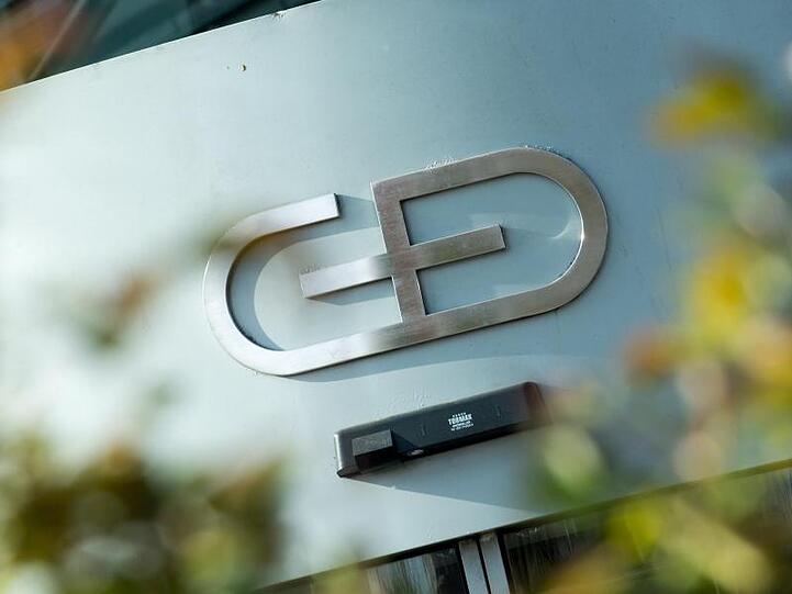 Das Firmenlogo am Gebäude der Zentrale von Giesecke+Devrient. Foto: Alexander Heinl/Archivbild