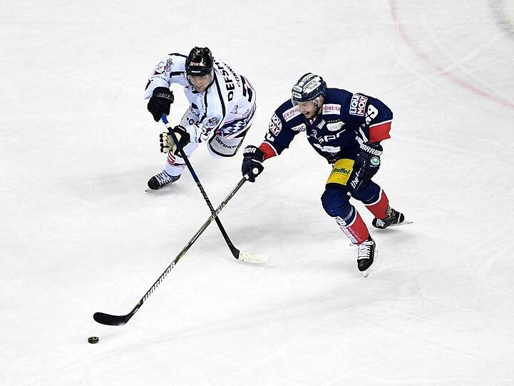 Berlins Florian Kettemer (l) und Straubings Mike Connolly kämpfen um den Puck. Foto: Britta Pedersen