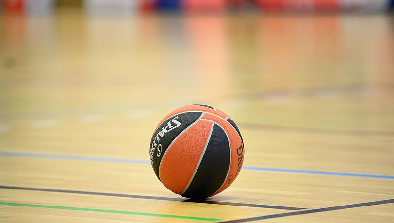 Ein Ball liegt auf einem Basketball-Spielfeld.