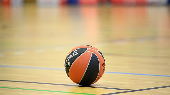 Ein Ball liegt auf einem Basketball-Spielfeld.