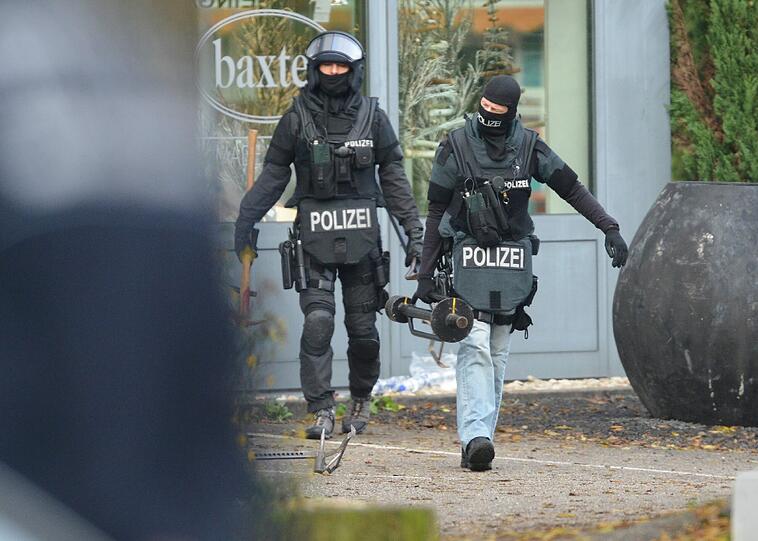 Mit erhobenen Händen kommt ein Mann auf die SEK-Beamten zu, im Hintergrund lauern Heckenschützen der Polizei. Die Beamten nehmen den Mann fest, es ist aber nicht der Täter, der sich in einem Imbiss in Freiburg veschanzt hat.