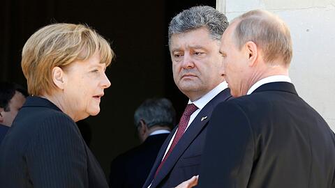 Kann sie die beiden zum Frieden drängen? - Bundeskanzlerin Angela Merkel mit dem ukrainischen Präsidenten Petro Poroschenko (M.) und Russlands Staatschef Wladimir Putin.